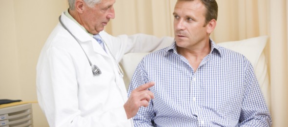 Doctor giving man checkup in exam room