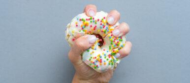 Hand,Squeezes,The,Doughnut.,One,Donut,With,White,Icing.,An